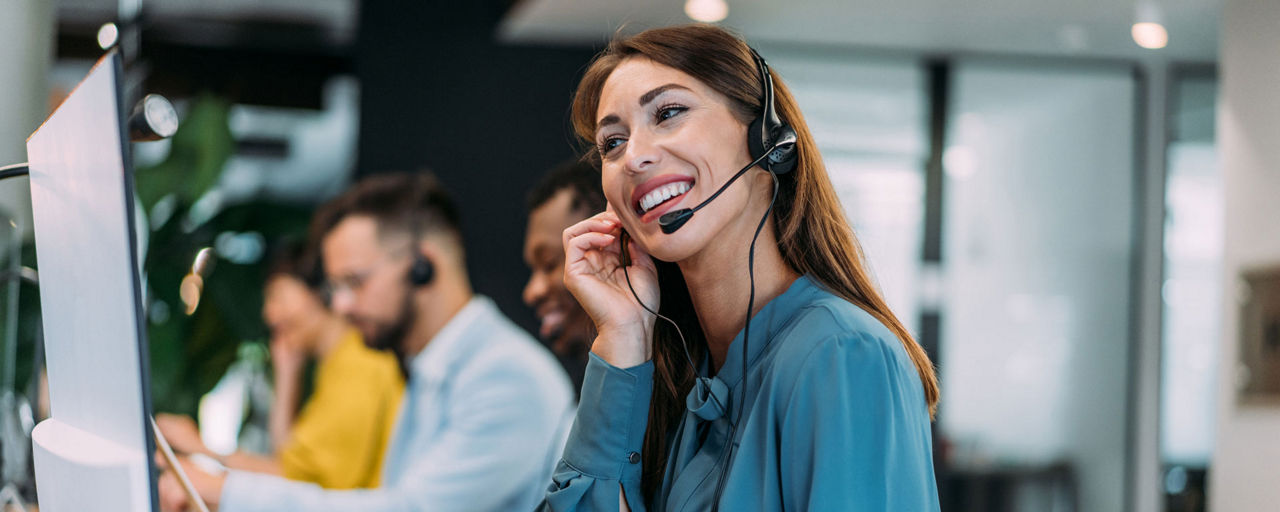 Ein Frau mit Headset im Büro beim Telefonieren