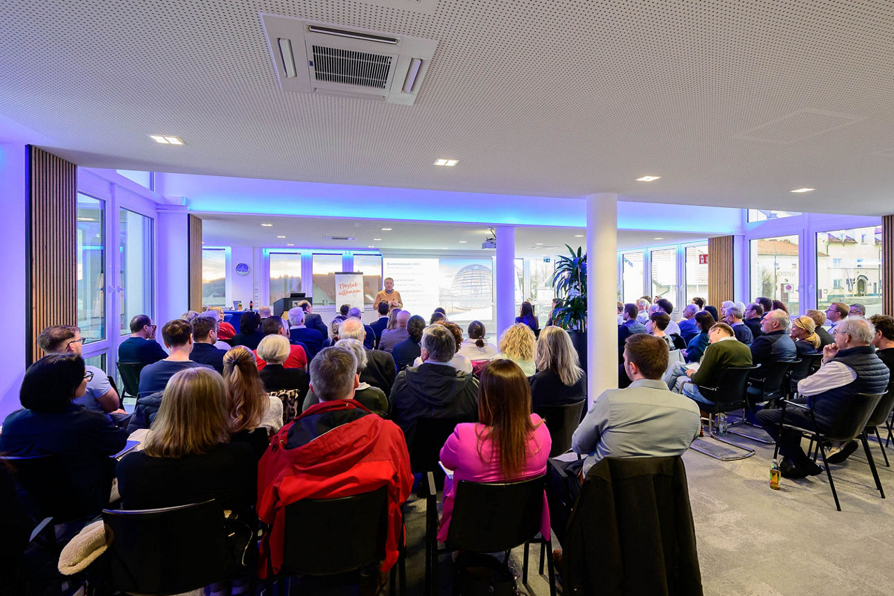 Publikum von hinten im Raum fotografiert.