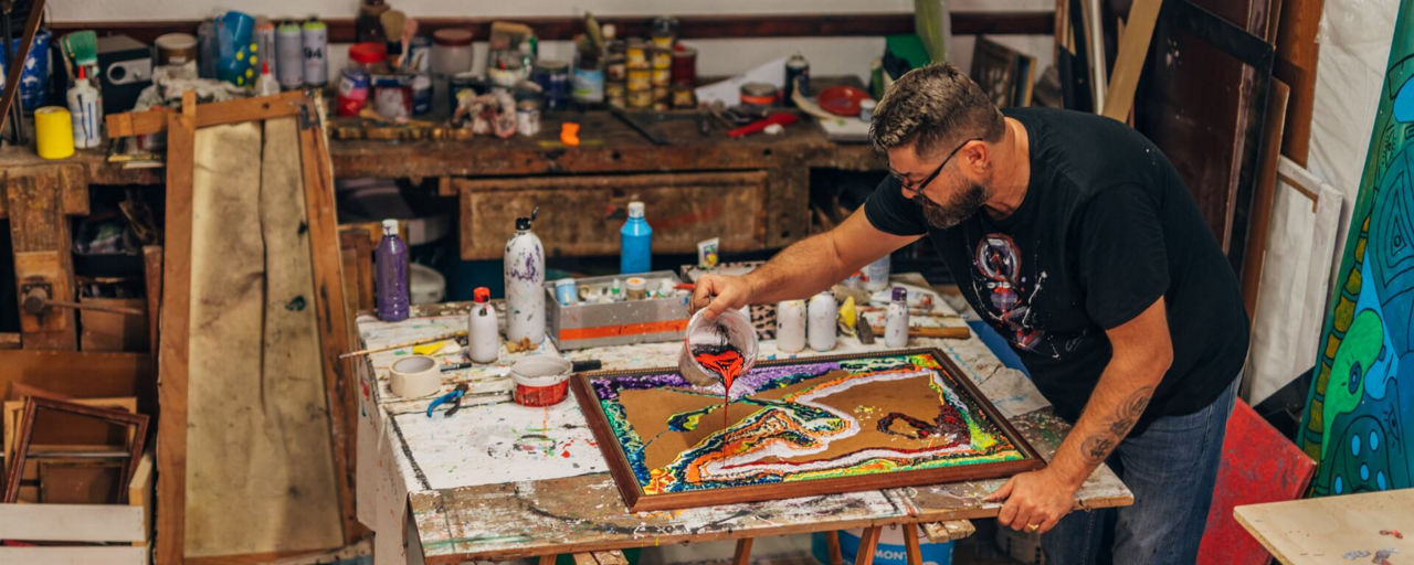 Künstler malt ein Bild in seinem Atelier voller Farben 