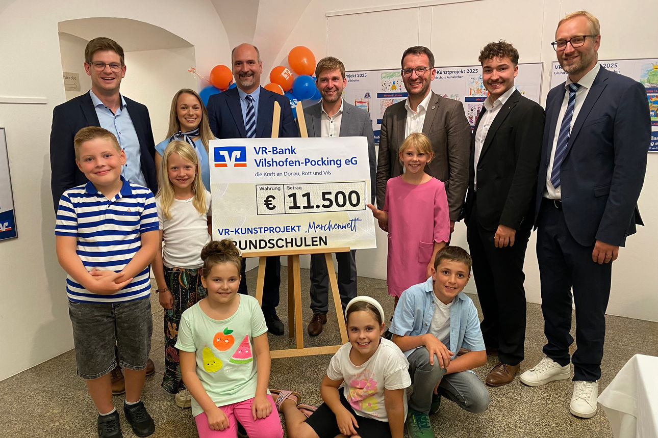 Mitarbeiter der Bank mit den Kindern und Spendenscheck