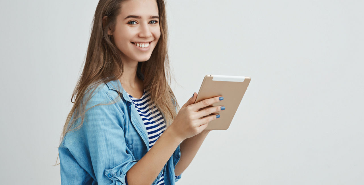 Bild von einer jungen Frau, die auf einer Treppe sitzt und ein Tablet in der Hand hält