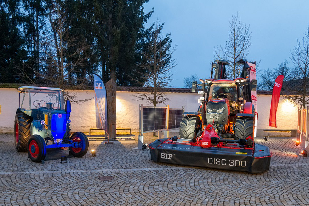 Ausgestellte und beleuchtete Traktoren in einem Innenhof