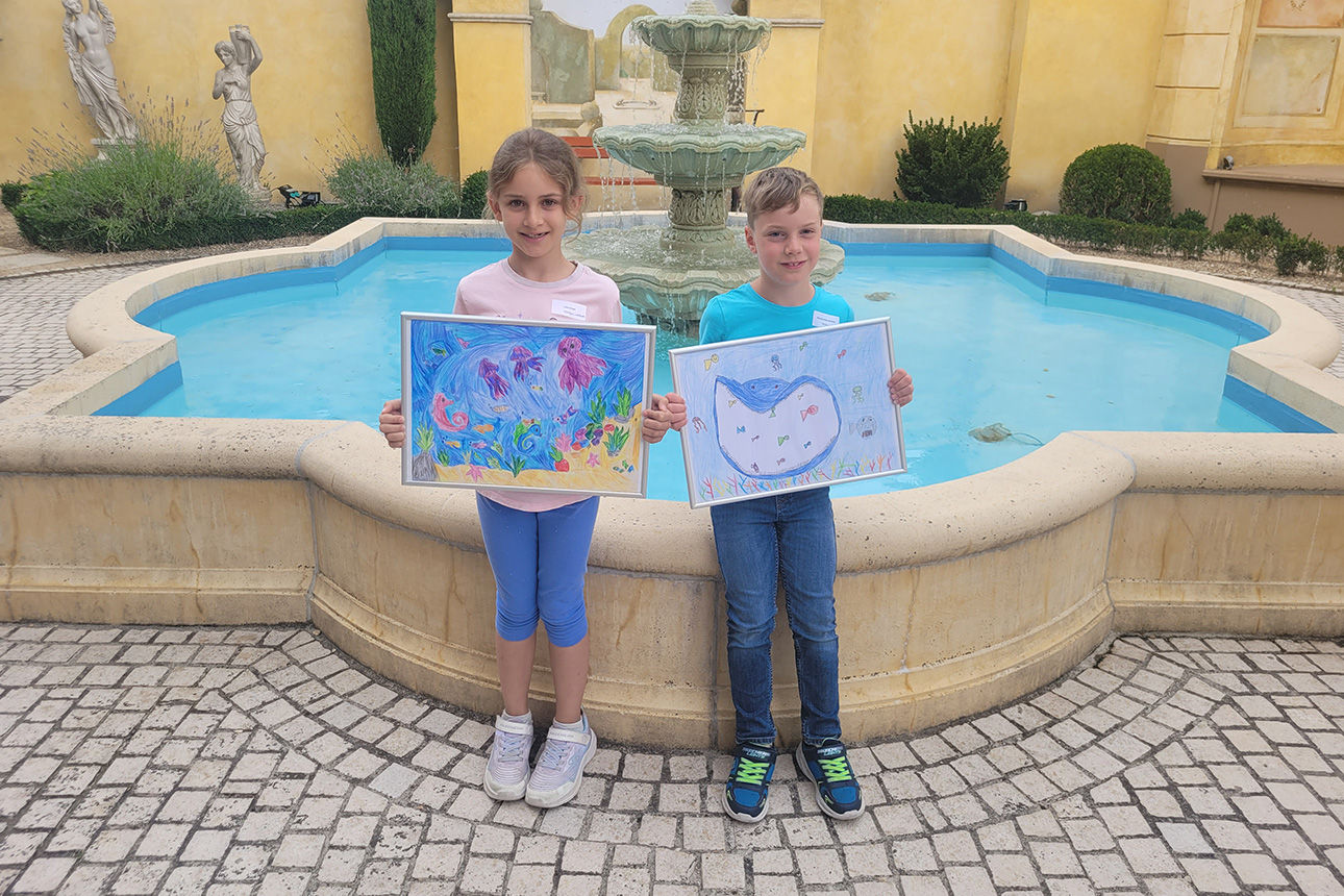 Die Landessieger stehen mit ihren Bildern vor einem Brunnen im Europa Park