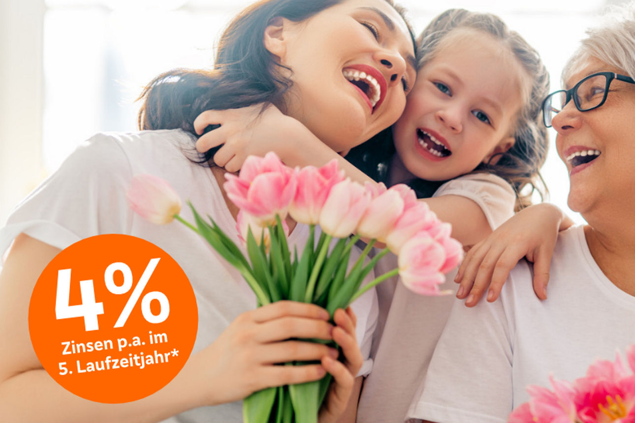 Mehrere Personen unterschiedlichen Alters stehen eng beieinander, halten rosafarbene Tulpen in den Händen.