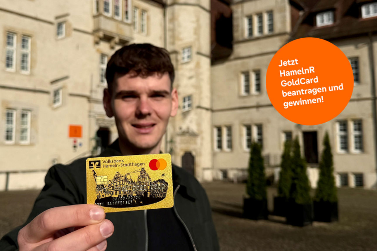 Eine Person hält eine goldene Kreditkarte mit Mastercard-Logo in die Kamera.