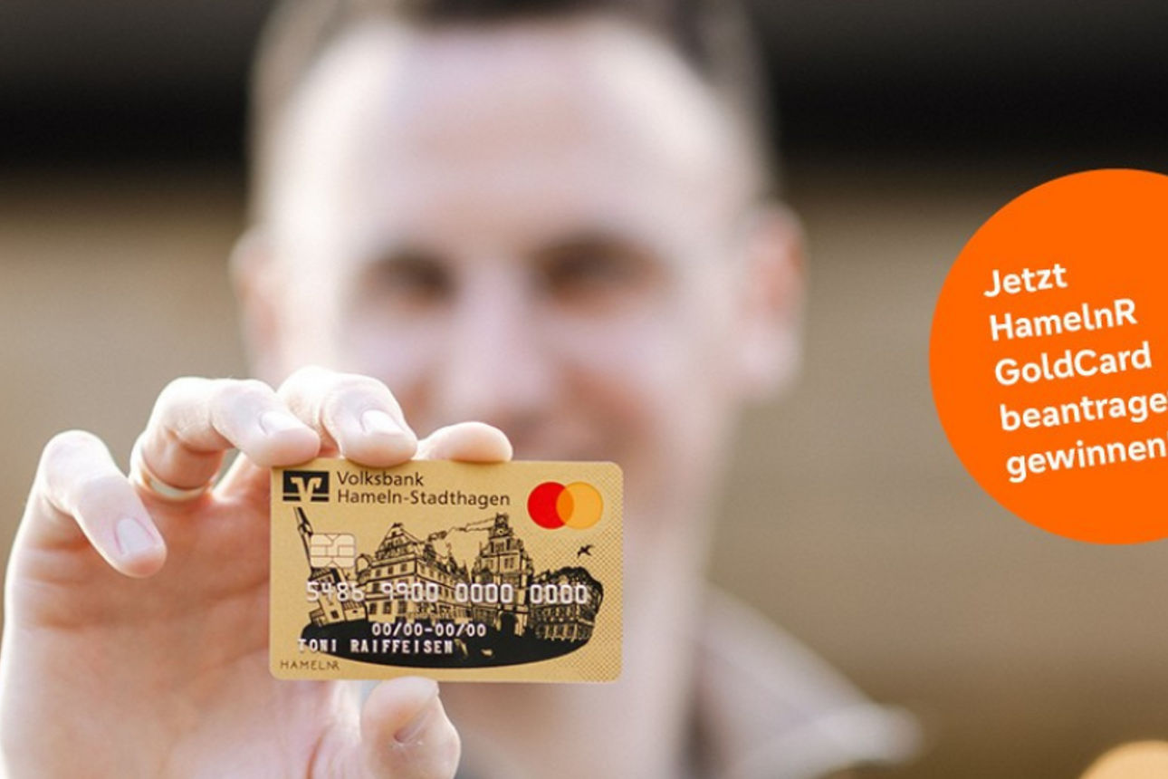 Eine Person hält eine goldene Kreditkarte mit Mastercard-Logo in die Kamera.