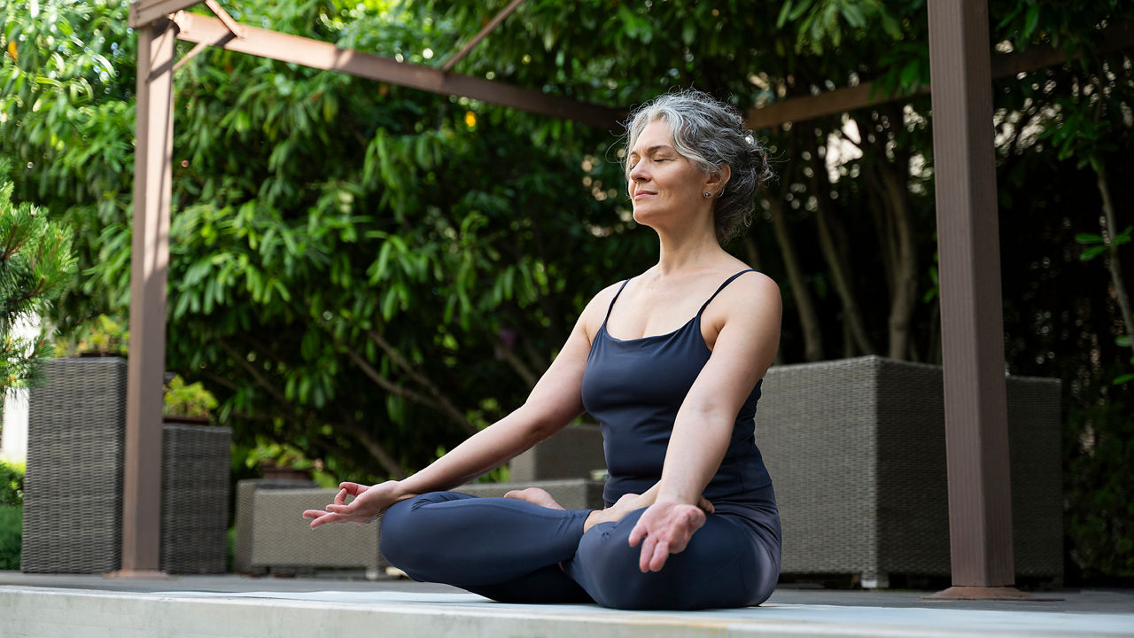 Eine Frau macht Yoga auf der Terrasse