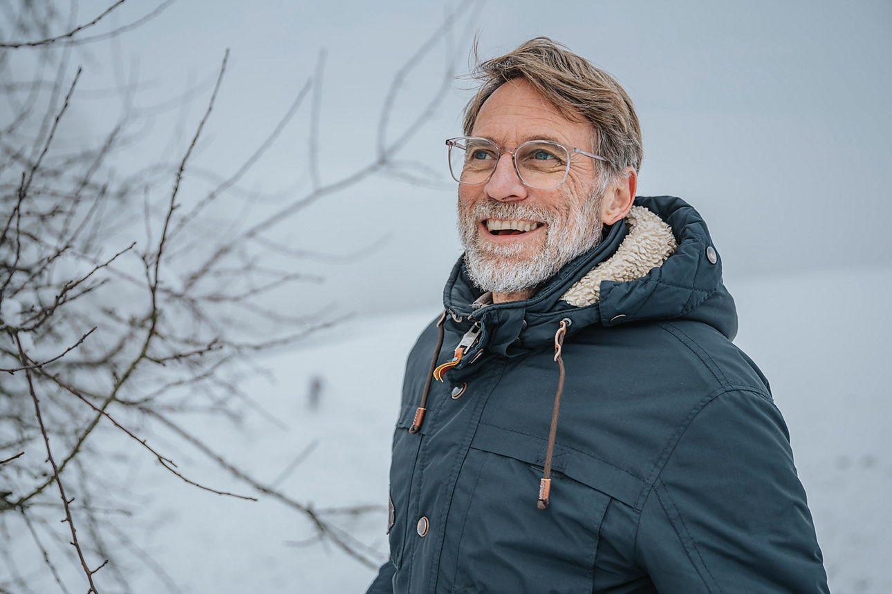 Ein Mann vor einer verschneiten Landschaft