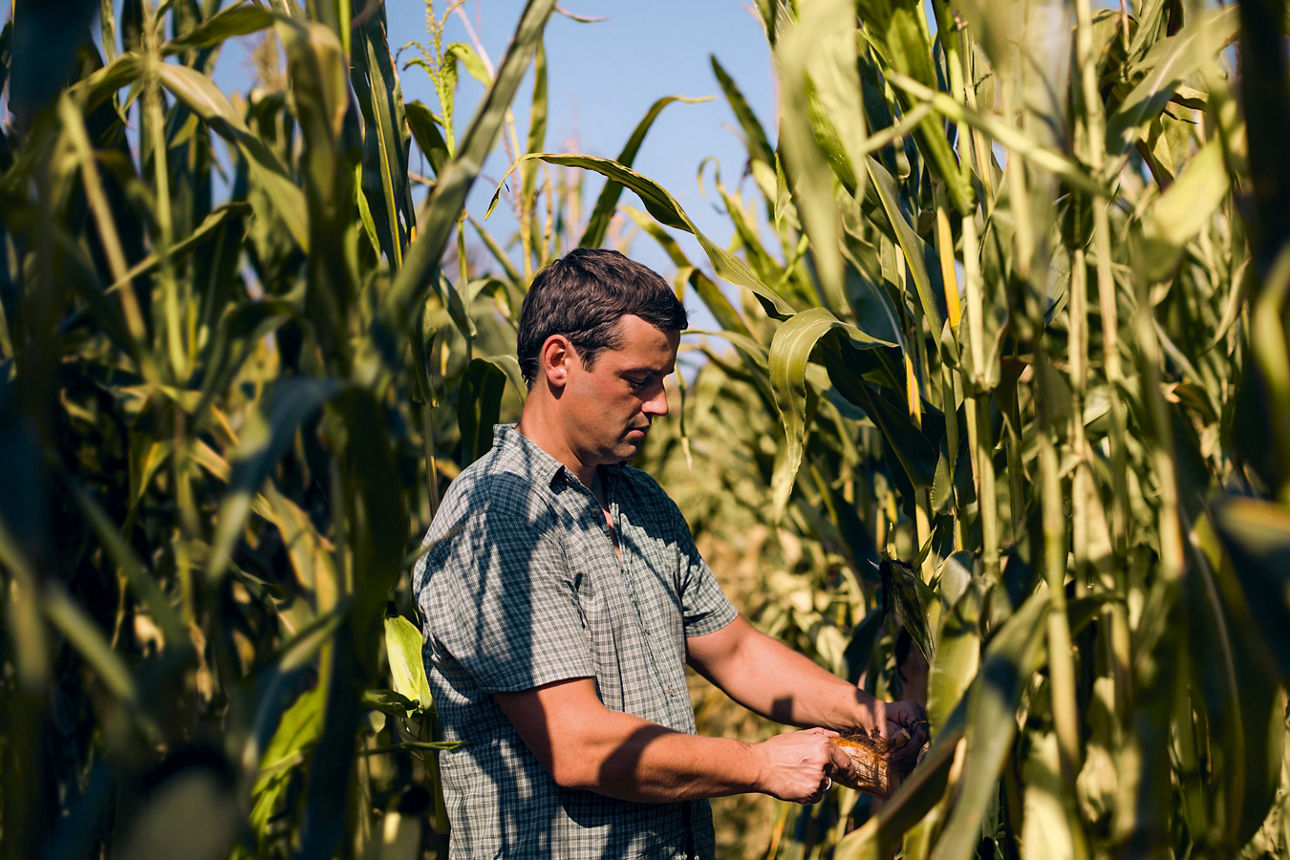 Ein Landwirt mit seinem Traktor vor einer E-Ladesäule