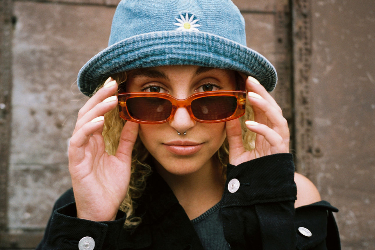 Frau mit Sonnenbrille und Jeanshut