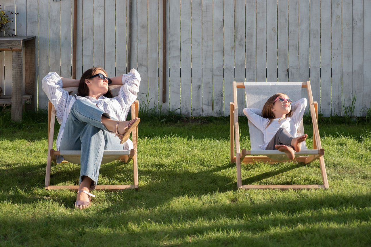Mutter und Tochter liegen im Sonnenstuhl
