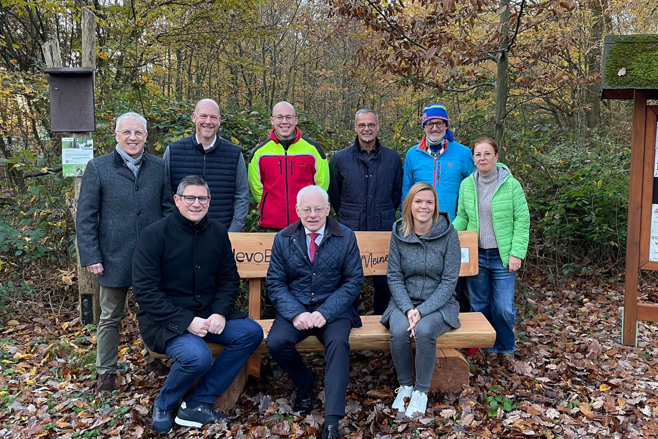 Gruppe sitzt auf einer Bank im Wald