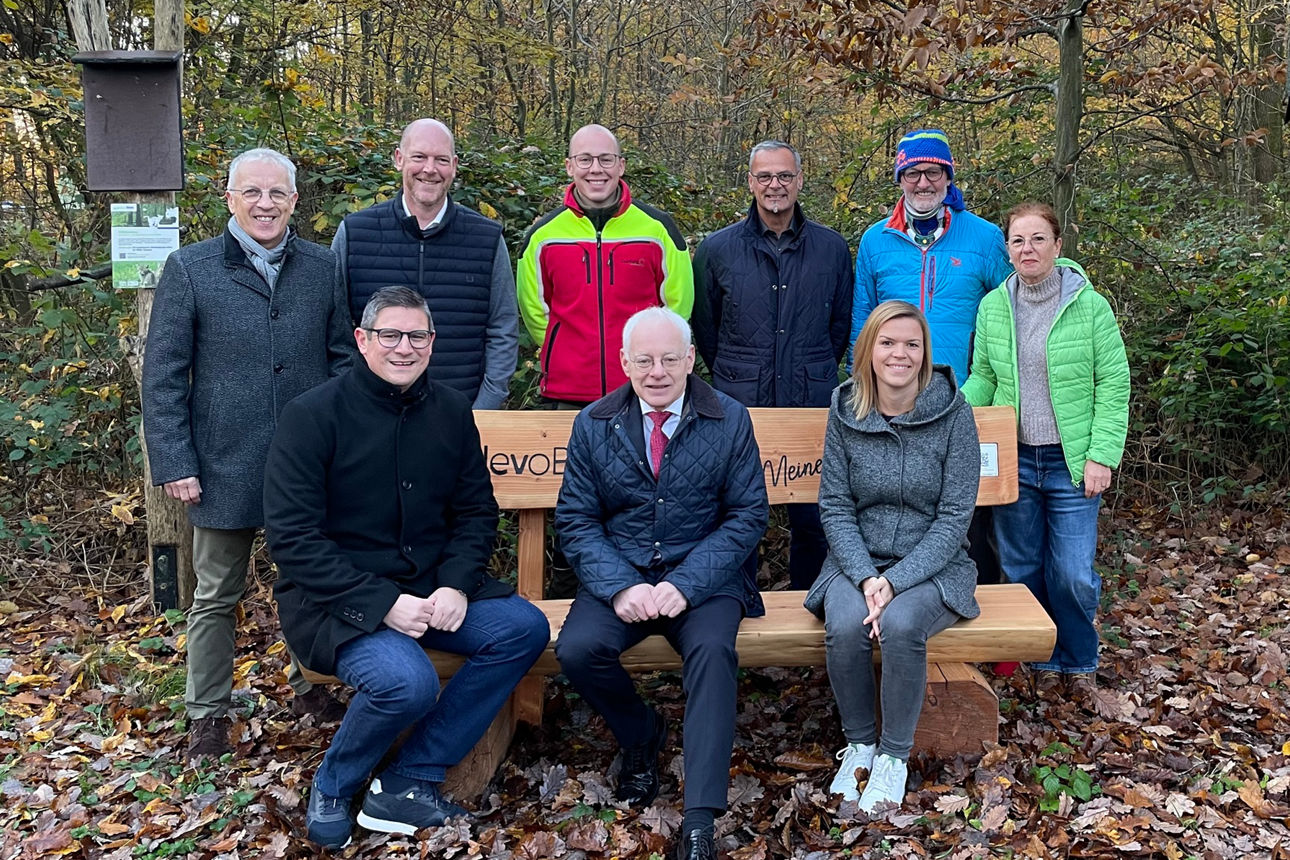 Gruppe sitzt auf einer Bank im Wald