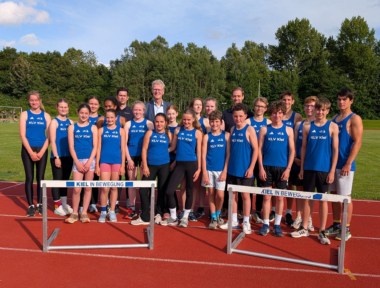 eine Leichtathletikgruppe steht vor zwei Sprunghindernissen
