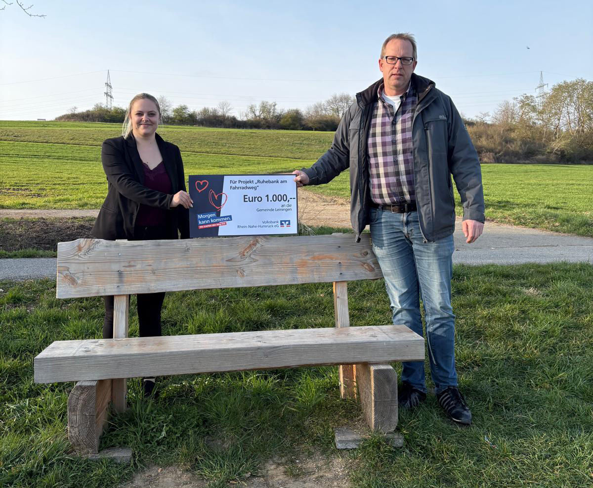 Zwei Erwachsene halten einen Spendenscheck in der Hand.