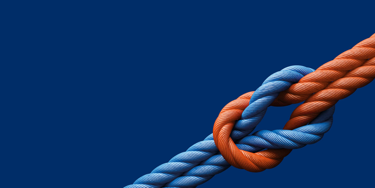 Knoten aus blauem und orangem Tau auf ultramarinem Hintergrund