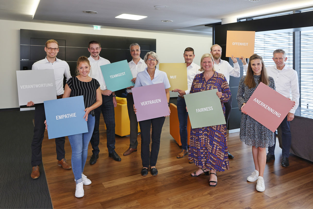 Eine Gruppe von Menschen mit farbigen Werten in ihren Händen