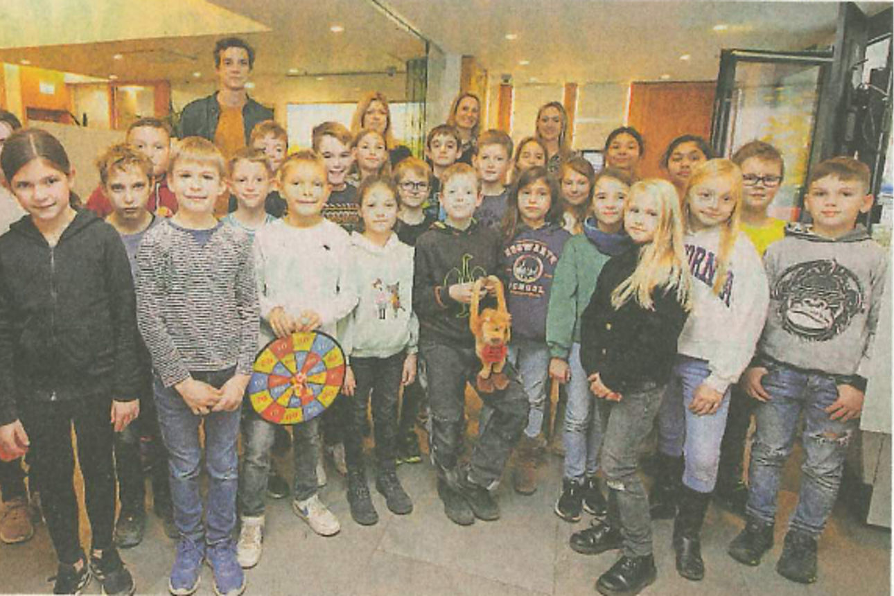 Eine Gruppe von Kindern, sowohl Jungen als auch Mädchen, steht in einer Reihe.