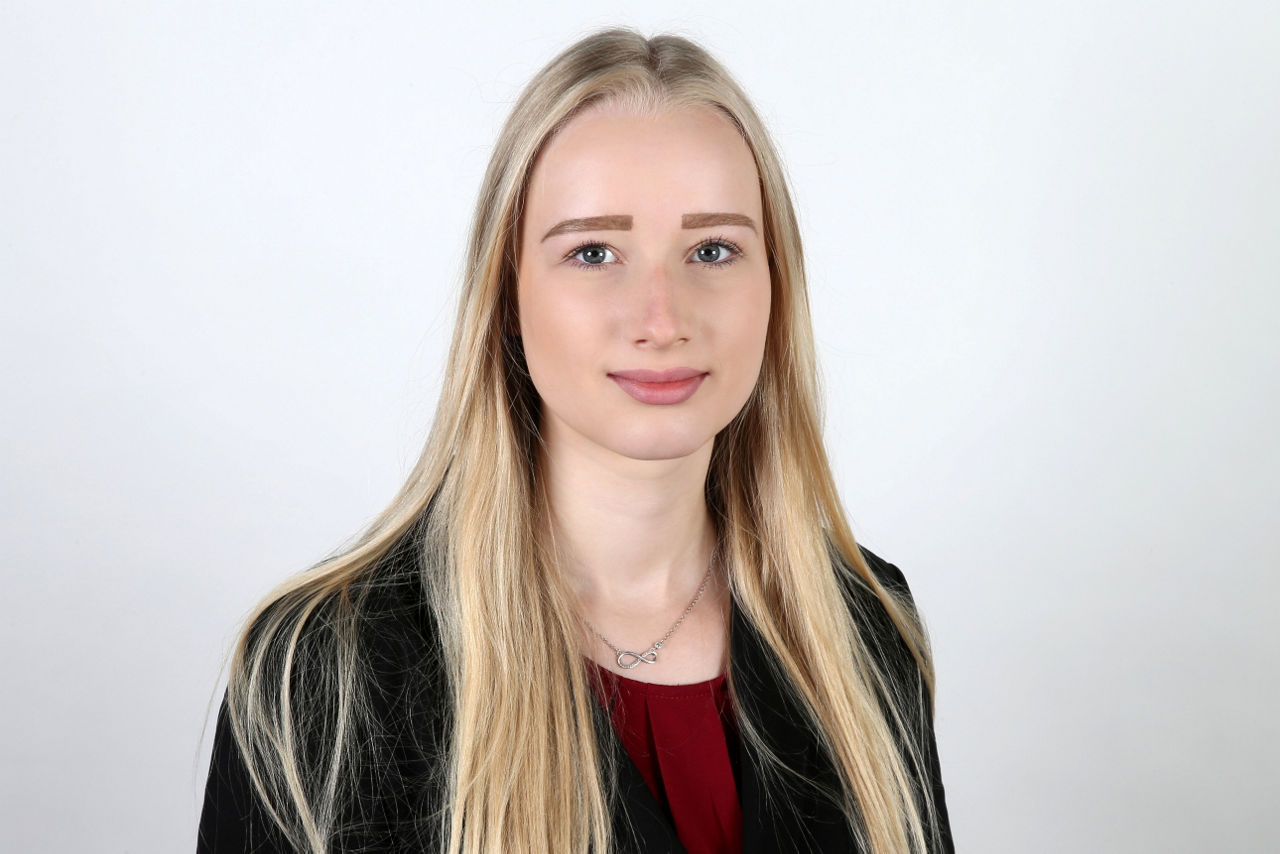 Eine lächelnder Frau schaut in die Kamera.