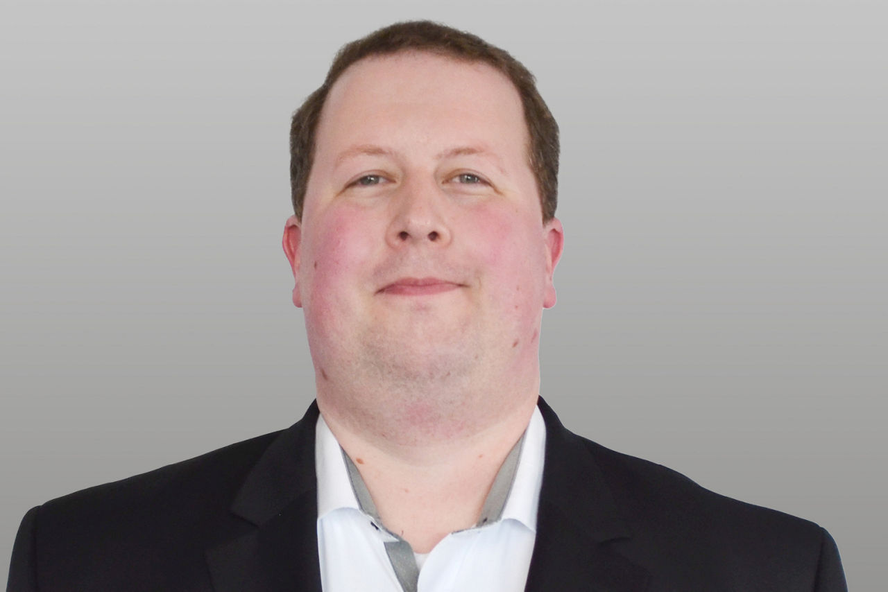 Privatkundenberater Julian Lieber vor grauen Hintergrund