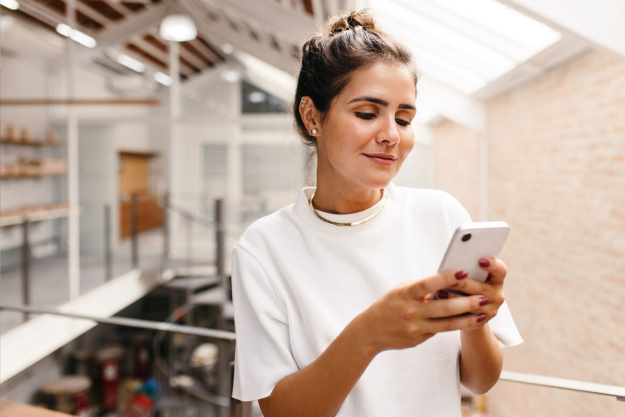 Junge Frau füllt eine Befragung auf dem Smartphone aus