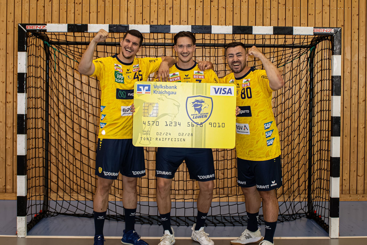 Drei Spieler der Rhein Neckar Löwen halten eine große Kreditkarte im Löwen-Design.
