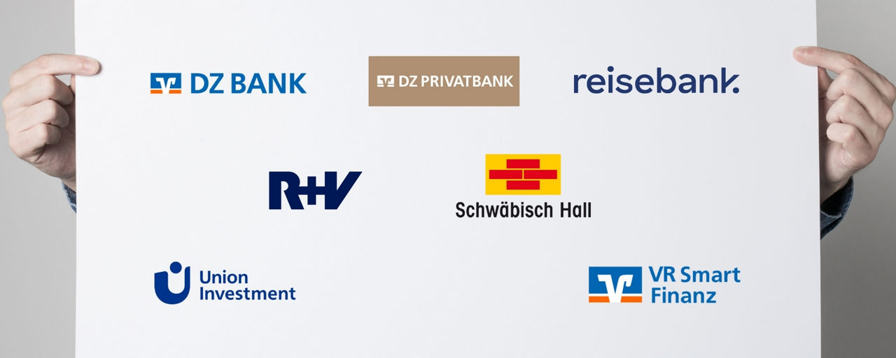 Person hält Plakat mit Logos der Unternehmen in der Genossenschaftlichen FinanzGruppe