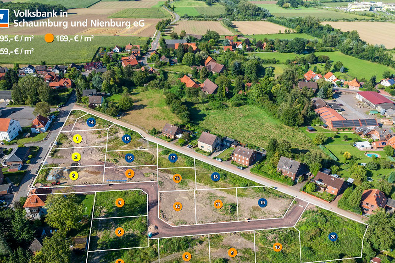 Luftaufnahme eines Wohngebiets mit Grundstücken, Straßen und Grünanlagen.