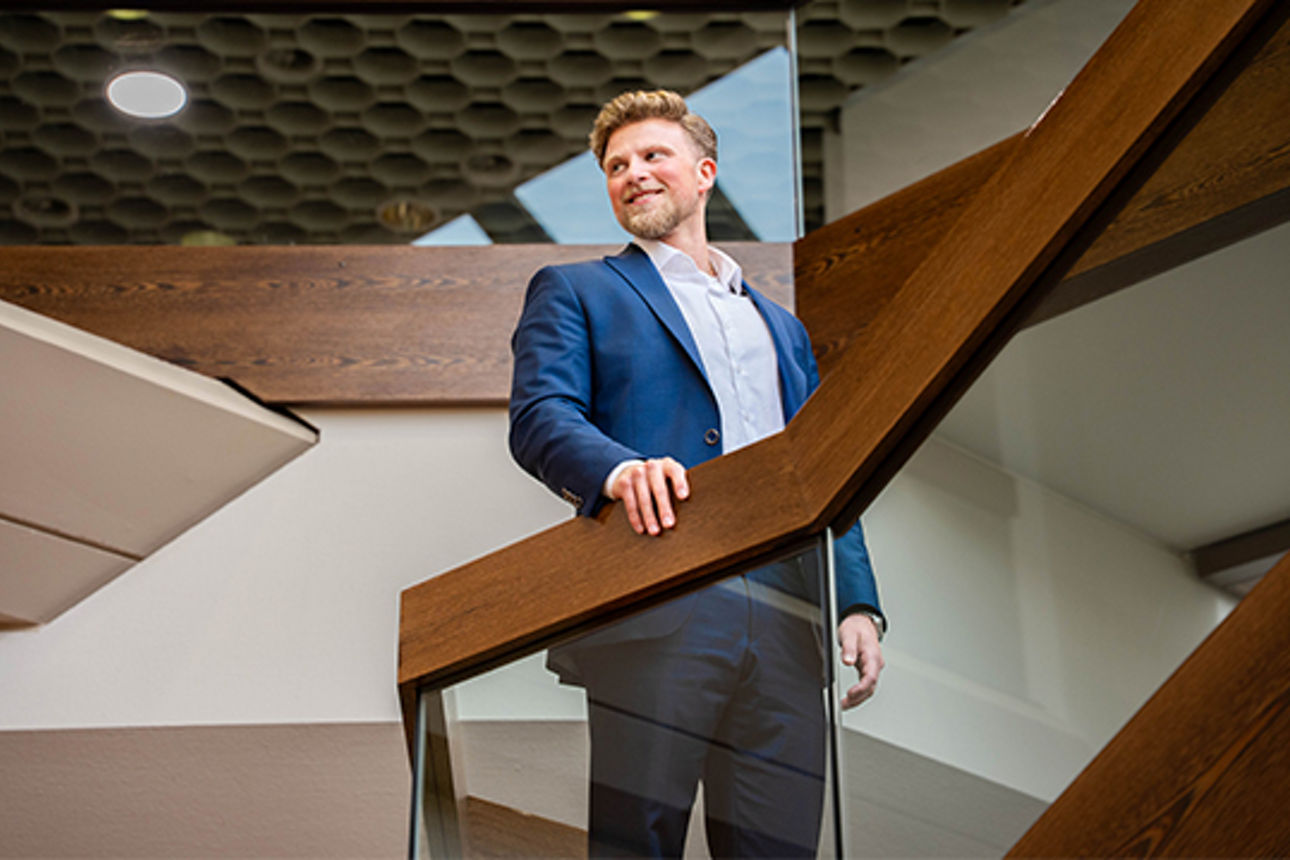 Junger Mann steht auf einer Treppe