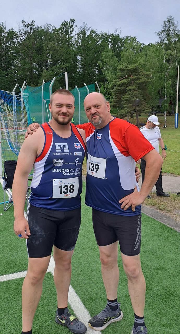 Zwei Männer in Sportkleidung umarmen sich, Vater und Sohn