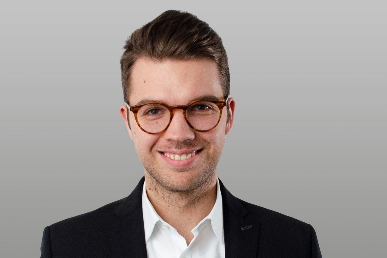 Firmenkundenberater Fabian Luley vor grauem Hintergrund