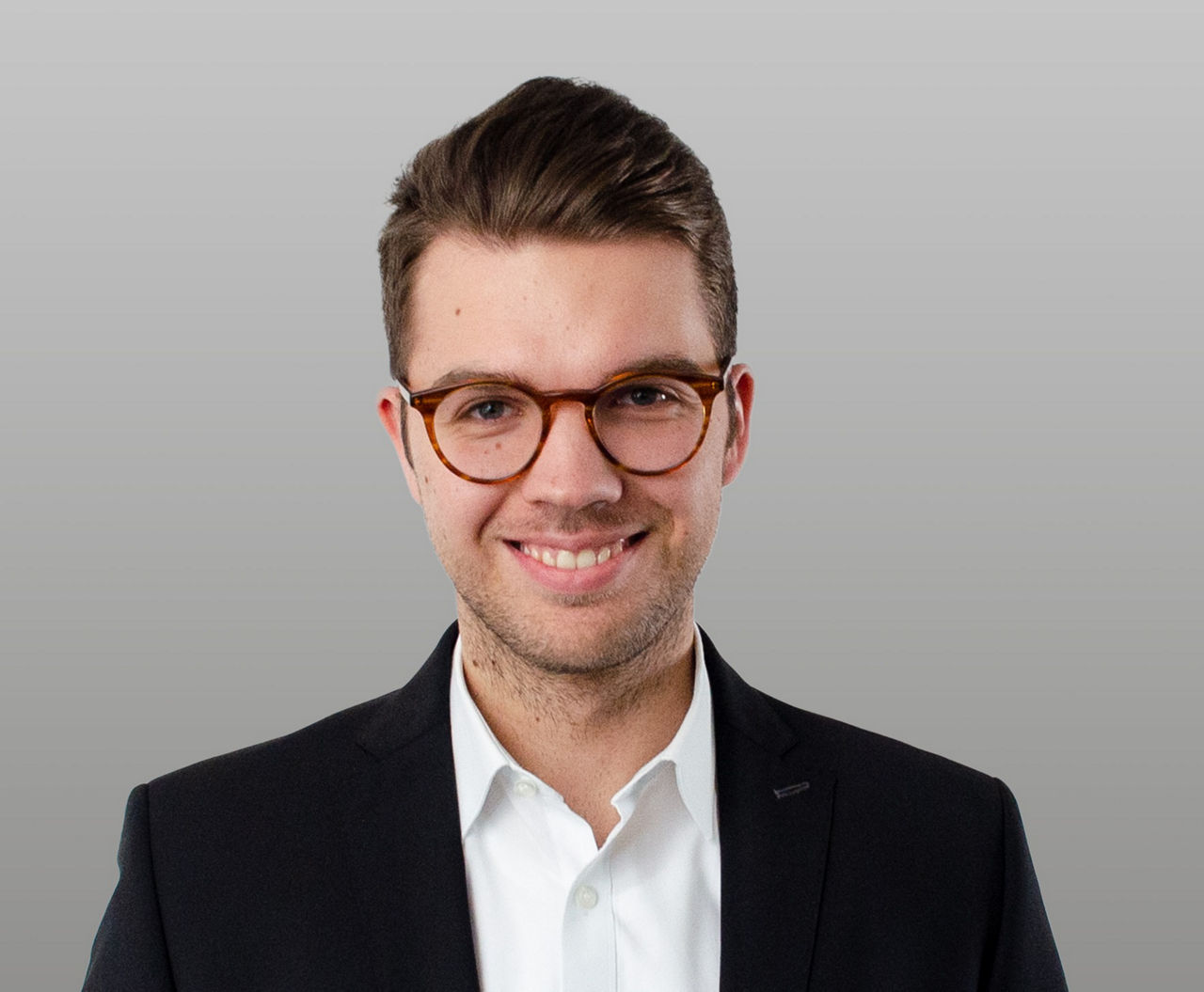 Firmenkundenberater Fabian Luley vor grauem Hintergrund
