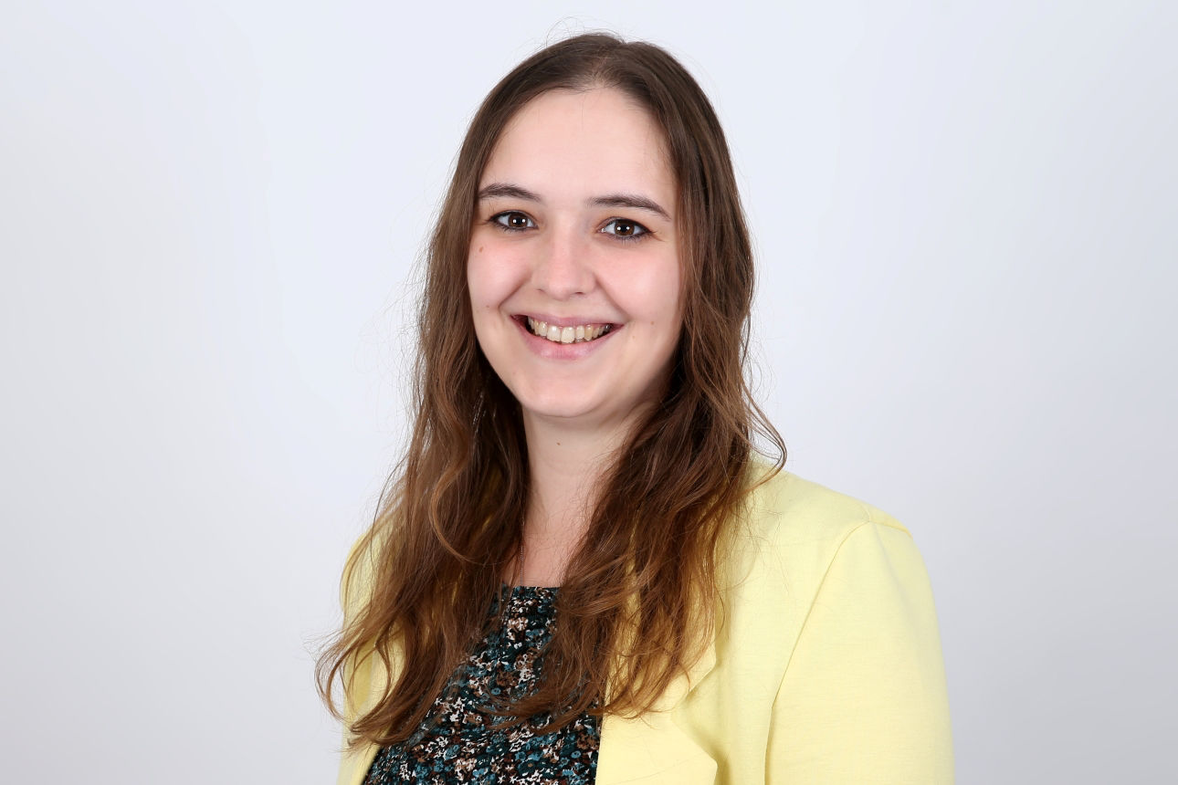 Eine lächelnde Frau schaut in die Kamera.