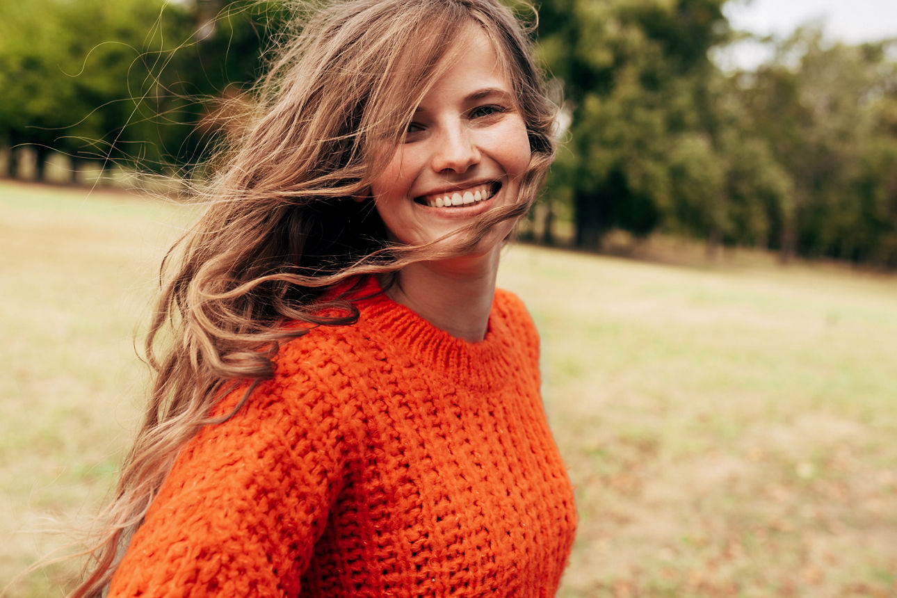 Junge Frau in orangenem Pullover