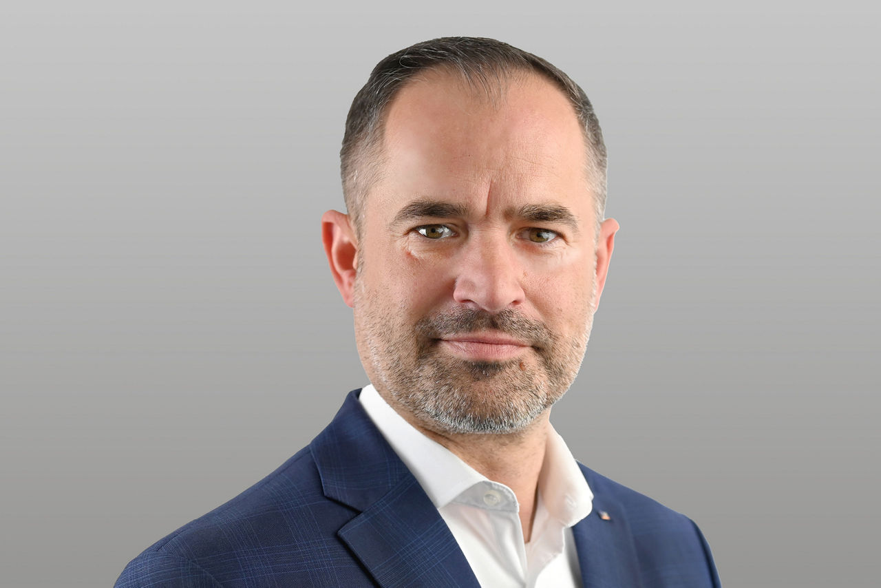 Geschäftskundenberater Rüdiger Möller vor grauem Hintergrund