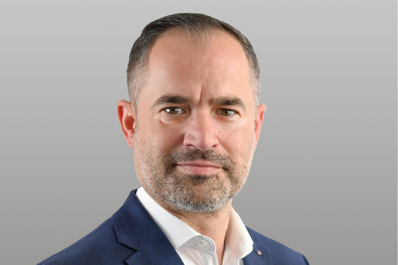 Geschäftskundenberater Rüdiger Möller vor grauem Hintergrund