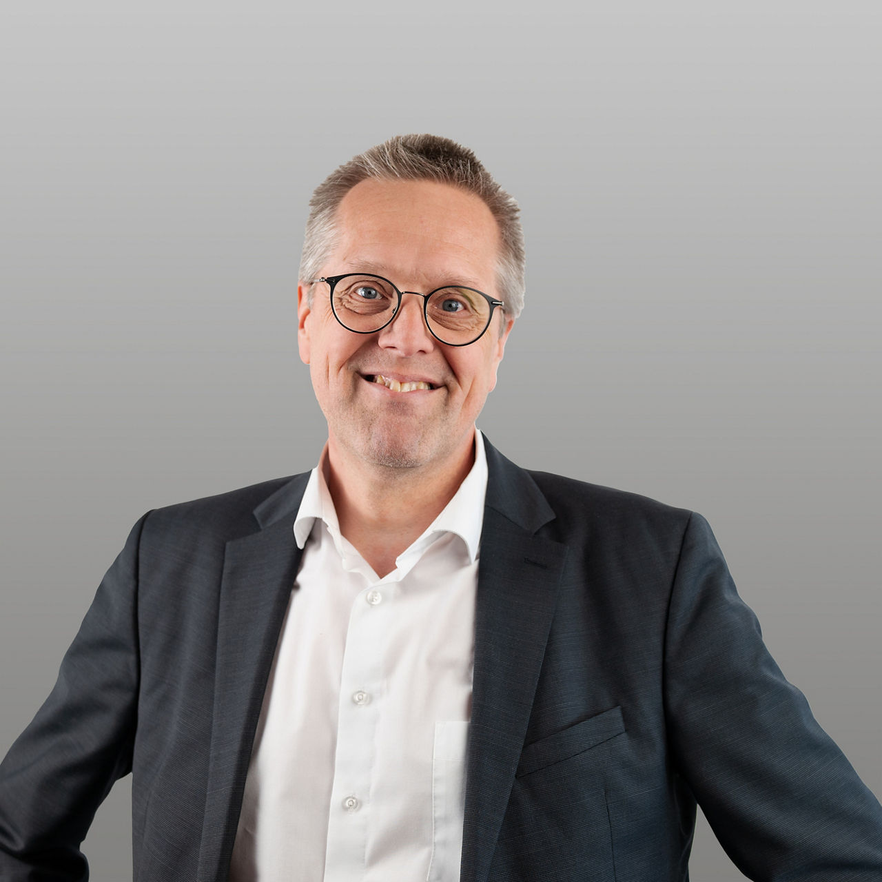 Firmenkundenberater Martin Müller vor grauem Hintergrund