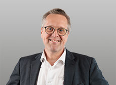 Martin Müller vor grauem Hintergrund
