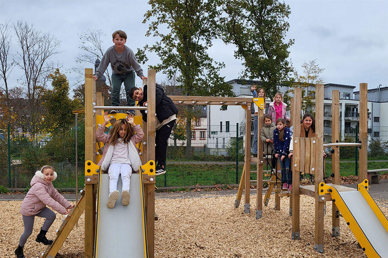Eine Gruppe Schülerinnen und Schüler toben auf einem Spielgerüst