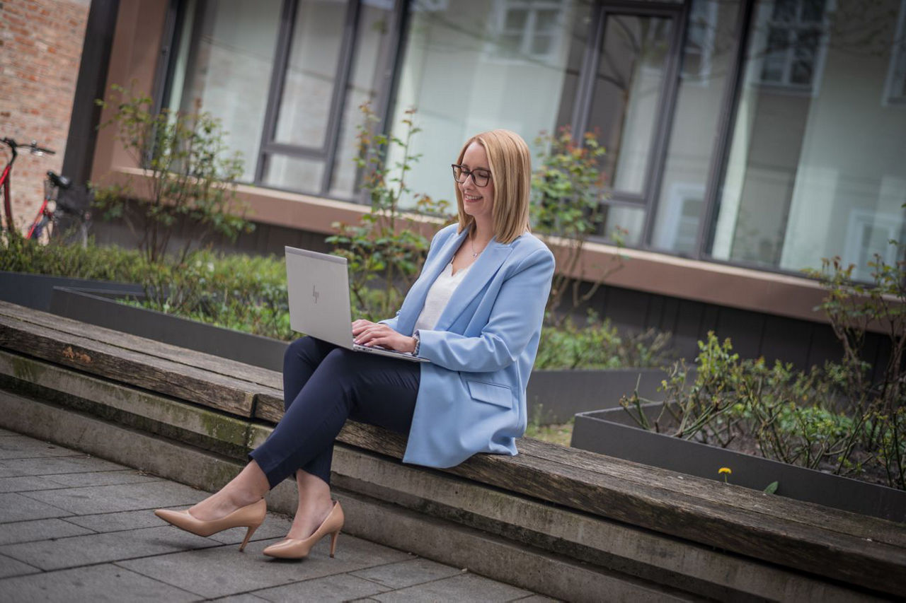 Mann sitzt mit Laptop in den Bergen und profitiert von den Services & Mehrwerten seiner Bank
