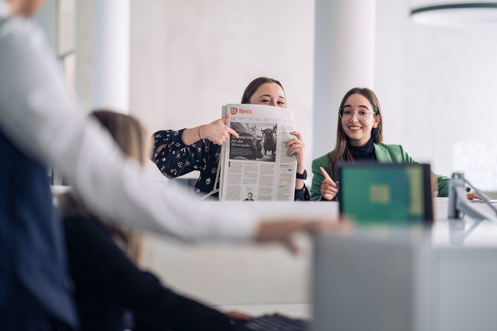 Schülerin zeigt auf eine Anzeige in einer Zeitung