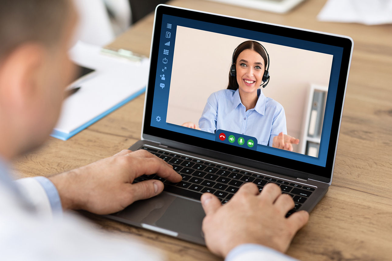 Mann sitz vor einem Laptop und führt ein Videogespräch mit einer Frau