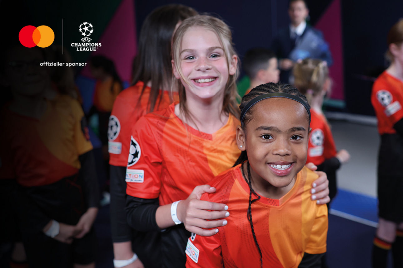 Kinder in Champions-League-Trikots lächeln in die Kamera – Symbolbild für das Mastercard Gewinnspiel der VR-Bank Ostbayern Mi