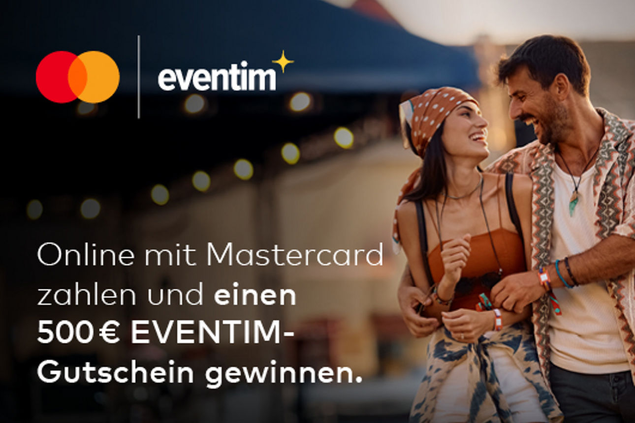 Ein junges Paar schaut sich verliebt auf einem Festival in die Augen.