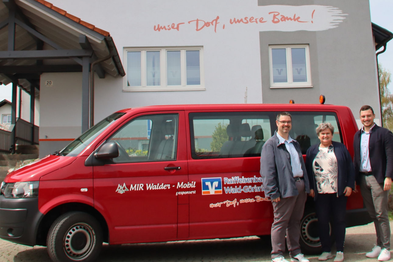 Christian Grimm, Michael Stapf und Johanna Purschke mit dem roten VW Bus vor dem Bankgebäude der Raiffeisenbank Wald