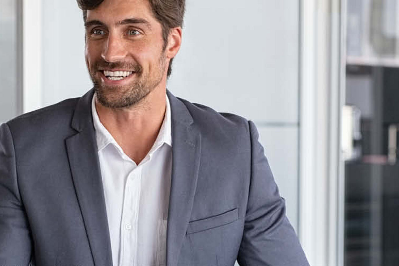 Ein Mann im Anzug schüttelt einem anderen Mann die Hand, um eine berufliche Vereinbarung zu symbolisieren