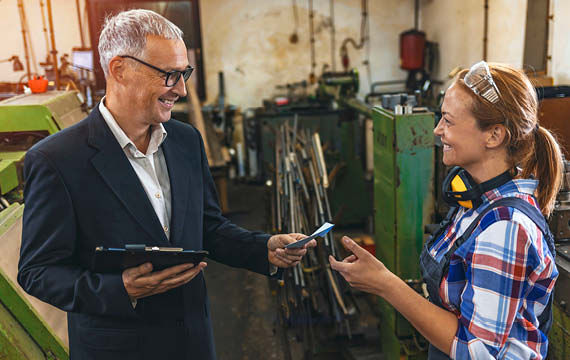 In einer Fabrik führen ein Mann und eine Frau ein Gespräch