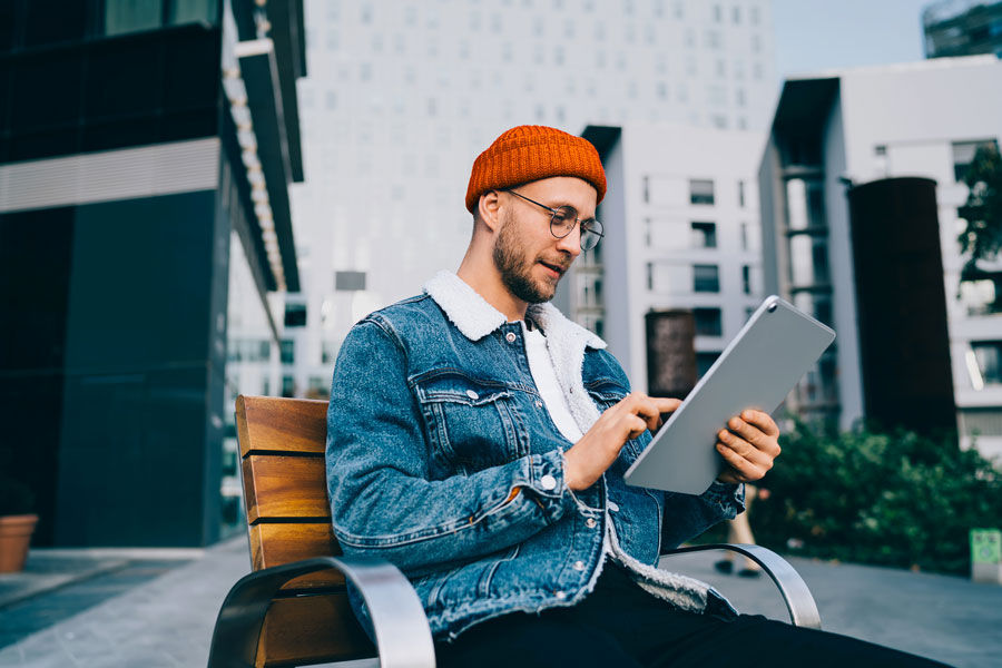 Mann liest Zeitung auf Tablet