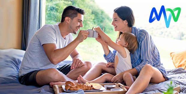 Junge Familie früshtckt gemeinsam im Bett