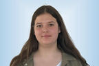 Praktikantin Maja Kraft vor hellblauem Hintergrund